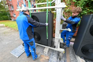 Zwei Männer bauen einen Wärmepumpen-Lift zusammen.